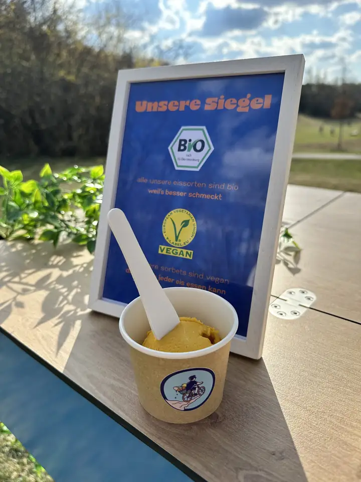 Bio-Mango-Sorbet im Becher vor dem Aufsteller mit Bio- und Vegan-Siegel